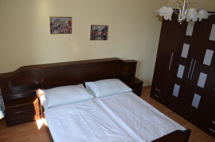 Schlafzimmer mit Doppelbett, Nachttischen und Kleiderschrank in warmen Farben